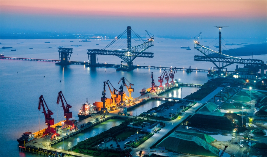2023年6月16日傍晚，长江边的江苏省泰兴市泰兴港灯光璀璨，与远处在建的常泰长江大桥。杨天民